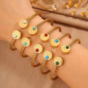 Détail de cinq bracelets torsadés avec breloques d'étoiles et pierres précieuses