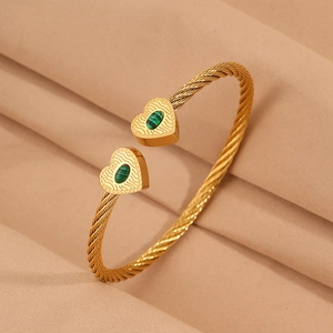 Close-up of gold-plated twisted rope bracelet featuring green malachite heart charms