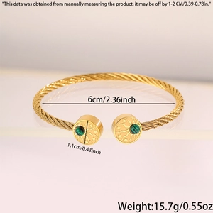 Détail du bracelet câble doré avec gravure soleil et étoile et pierre verte