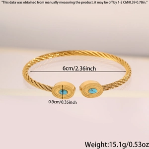 Détail du bracelet rigide torsadé doré avec deux pierres ovales bleues symétriques