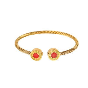 Bracelet câble doré avec pierre rouge et motif de méandre grec aux extrémités
