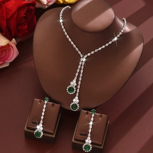 Primer plano de conjunto de joyas de circón verde esmeralda con collar y pendientes largos