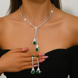 Primer plano del elegante collar en Y y pendientes colgantes con circón verde en modelo