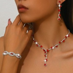 Luxury bridal jewelry set featuring sparkling red gemstones and white crystals on a model