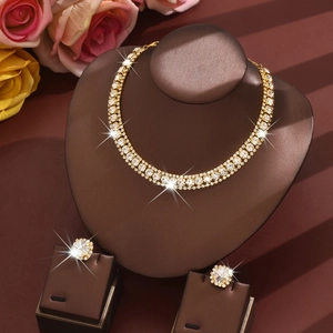 Elegantes goldfarbenes Kristallschmuckset mit Halskette und Blumenohrringen auf dem Display