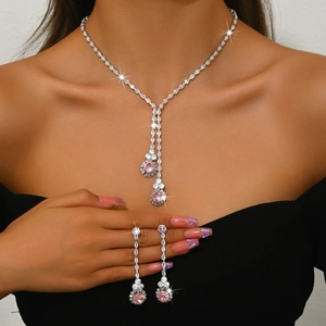 Detalle del elegante collar en Y y pendientes largos con circón rosa en una modelo