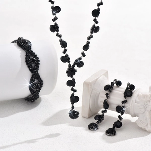 Detailed view of bridal crystal jewelry set with black rhinestones on stone pillars
