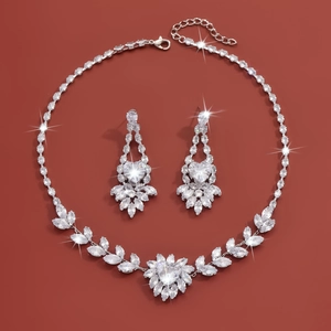 Detailed view of silver necklace and drop earrings with sparkling heart-shaped zircons