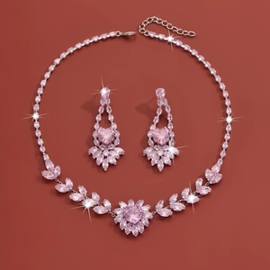 Detailed view of jewelry set with pink heart-shaped zircons and silver flower motifs