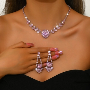 Close-up of model wearing pink heart-shaped crystal necklace and drop earring jewelry set