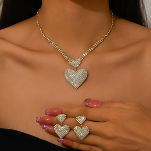 Primer plano de un conjunto de collar y pendientes de corazón brillantes en una modelo