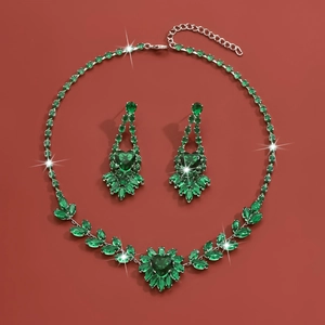 Detailed view of jewelry set with green heart-shaped gemstones and sparkling silver finish