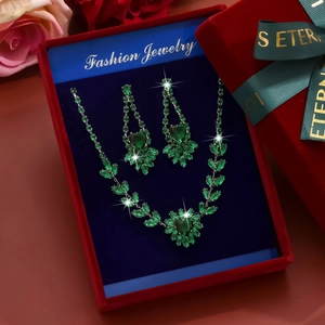 Green emerald heart necklace and earrings set in a red velvet box with eternal ribbon