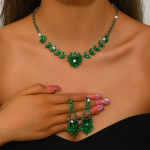Close-up of emerald green zircon jewelry set with floral necklace and long drop earrings
