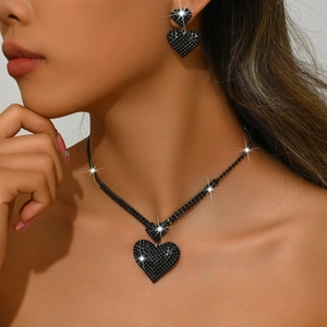 Detalle de un elegante conjunto de collar y pendientes de corazón negro con cristales finos