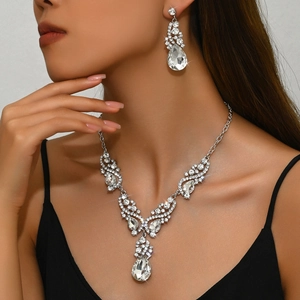 Elegant teardrop crystal wedding necklace and earrings set on female model in black dress