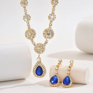 Macro detail of jewelry set with blue pear-cut stones and white zircon clusters