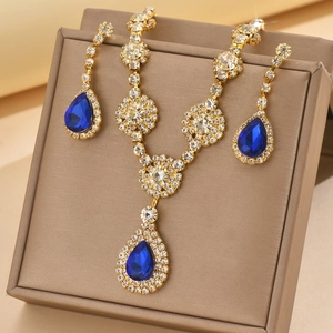 Close-up of gold jewelry set with blue pear-shaped stones and sparkling zircons