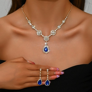 Close-up of elegant model wearing blue teardrop zircon necklace and matching earrings