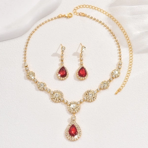 Detail of luxury gold jewelry set with pear-cut red gems and sparkling zircon stones