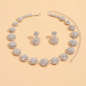Detalle de conjunto de joyería nupcial con collar y pendientes de cristales resplandecientes