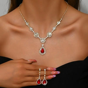 Luxury jewelry set with red pear-shaped gemstones and white zircon in gold finish