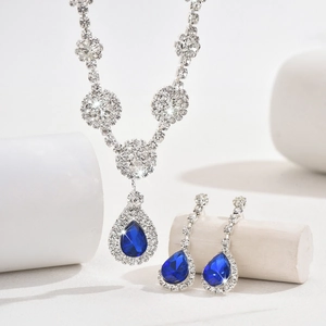 Detailed macro shot of silver zircon jewelry set featuring blue teardrop gemstones