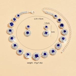 Detalle de set de joyas nupciales plateadas con cristales azul oscuro y circonitas