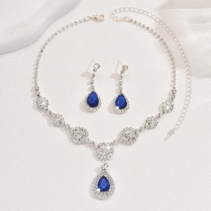 Macro shot of silver-tone jewelry set with pear-cut blue stones and zircon crystal accents