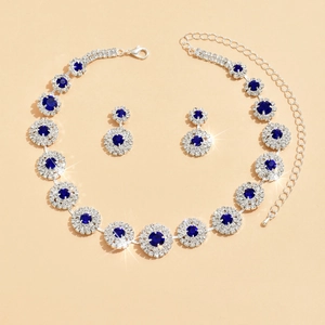 Detalle de conjunto de collar y pendientes plateados con cristales azul oscuro y diamantes
