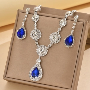 Detail of luxury teardrop blue crystal jewelry set on a textured display box
