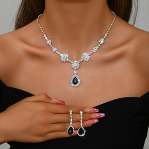 Elegant silver-tone jewelry set with black pear-shaped stones and zircons on model