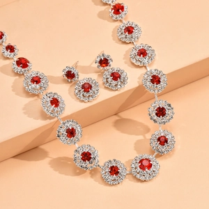Detalle de set de joyas nupciales con piedras rojas, collar y pendientes de plata fina