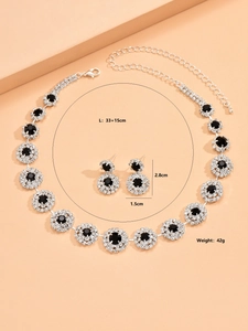 Detalle del conjunto de joyería nupcial con piedras negras y diseño floral plata