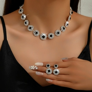 Elegante conjunto de collar y pendientes plateados con cristales negros en una modelo