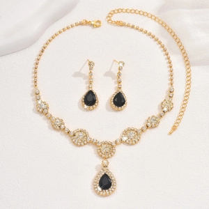 Detail of gold zircon jewelry set featuring black pear-shaped pendants and shiny crystals