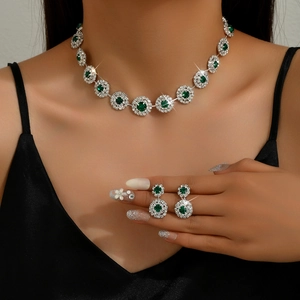 Detalle de set de joyas nupciales de lujo con piedras verde esmeralda y diamantes