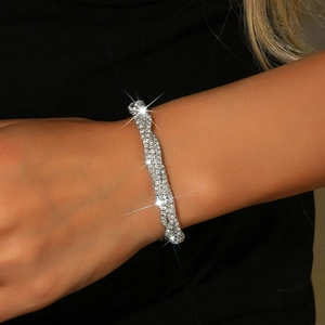 Detail of multi-row twisted silver bracelet with sparkling pavé rhinestones on wrist
