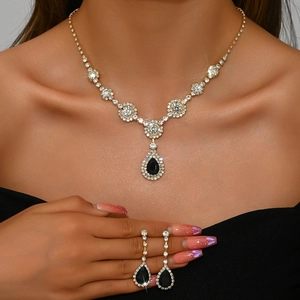 Detail of luxury necklace and earrings set featuring black pear-cut gemstones and zircons