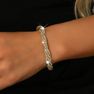 Detailed view of luxury gold multilayer twisted bracelet with sparkling rhinestones on wrist
