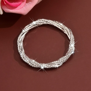 Macro detail of multi-layered silver bracelet with sparkling pavé rhinestones on leather