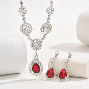 Macro detail of red pear-cut zircon necklace and earrings set in silver finish