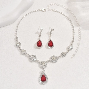 Detail of necklace and pear-cut red stone earrings with sparkling zircon pave setting