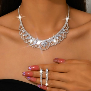 Detail view of lace-style rhinestone necklace and matching tassel earrings on model