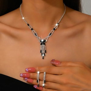 Detail of luxury evening jewelry set with black rhinestones and silver tassels on a model
