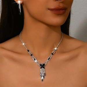 Elegant silver-tone jewelry set with black and white rhinestones on a female model