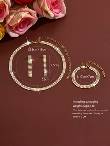 Macro shot of gold-plated jewelry set with multi-row rhinestones and floral background