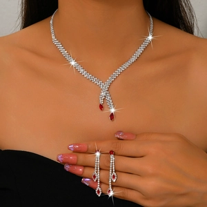 Detalle de un set de joyas de novia con gemas rojas en forma de pera y circonitas brillantes