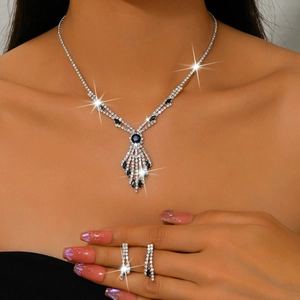 Detailed view of rhinestone necklace and matching tassel earrings with blue stones