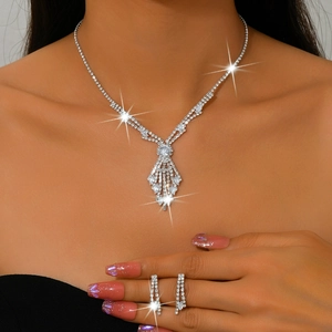 Close-up of sparkling rhinestone necklace and long tassel earrings on a model